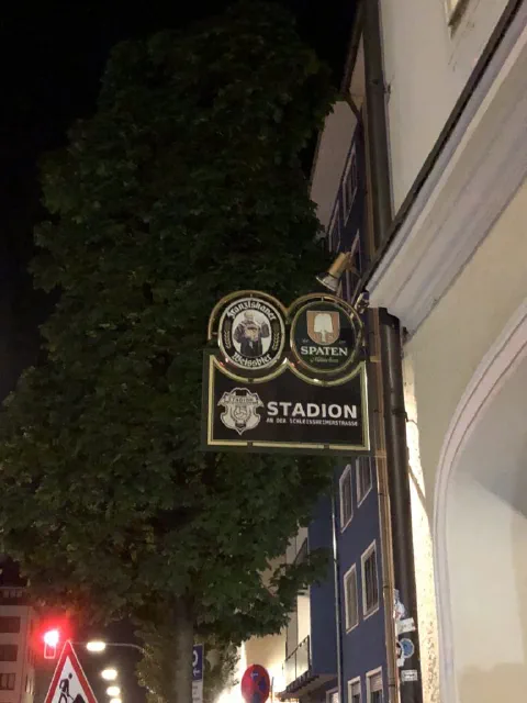 Beleuchtetes Schild der Gaststätte Stadion an der Schleißheimer Straße in München bei Nacht